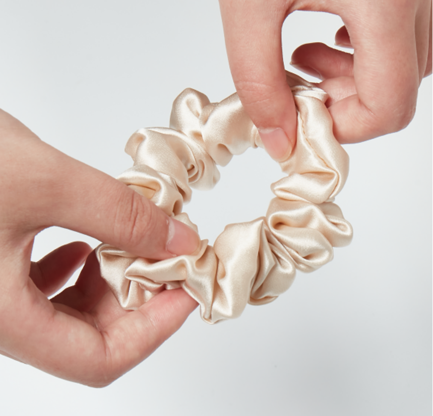 Close view of a silk scrunchie texture and gathered construction